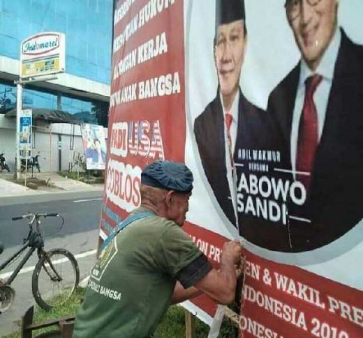 Sedih Lihat Baleho Prabowo-Sandi Disobek, Kakek Renta Ini Berusaha Menjahitnya